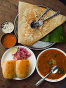 A traditional Indian meal includes cheese masala dosa and pao bhaji.